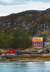 Old Norwegian red wooden houses on rocky coast