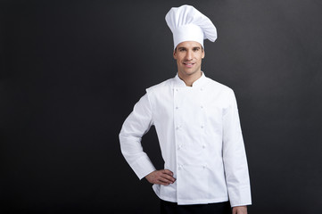 Smiling cook against dark background smiling at camera