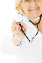 Senior Female Doctor Holding Stethoscope Over White Background