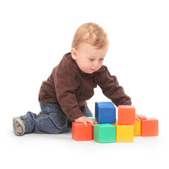 Little kid playing with toy blocks on a white background.