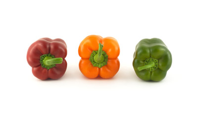 Three whole color ripe bell peppers in-line isolated close up