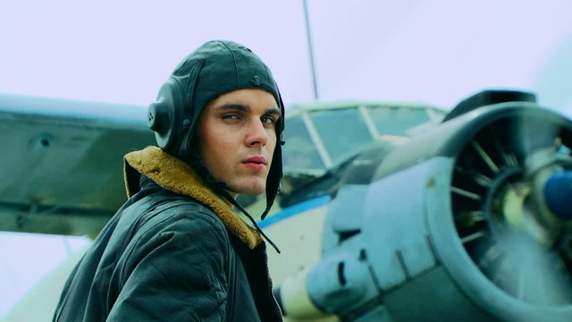 Young pilot in front of a retro plane