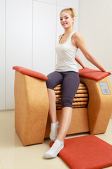 Girl in sportwear on relax massage equipment healthy spa salon