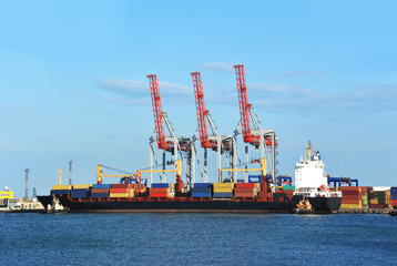 Container stack and ship under crane bridge