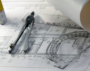 Dividers and a protractor on a draft, closeup.