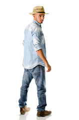 Fototapeta premium Trendy young man with jeans, denim shirt and straw hat