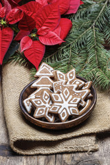 Bowl of gingerbread cookies on jute napkin. Fir and poinsettia