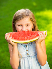 Cute little girl eating watermelon