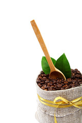 Coffee beans in a canvas bag and a wooden spoon.