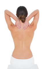 Rear view of a topless woman suffering from neck ache
