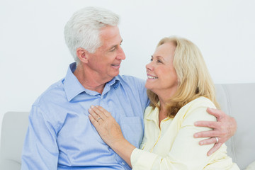 Happy romantic senior couple sitting on sofa