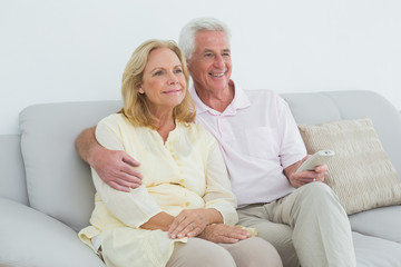 Obraz premium Relaxed happy senior couple with remote control