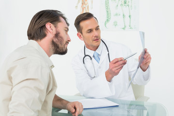 Male doctor explaining spine x-ray to patient