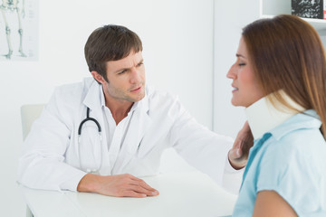 Doctor examining a patient's neck in medical office