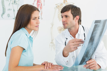 Fototapeta premium Doctor explaining spine x-ray to female patient