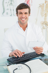 Fototapeta na wymiar Portrait of a male doctor reading a note at desk