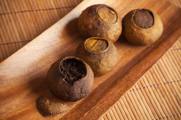 Chinese tea Pu-erh packed in dried mandarins on wooden table