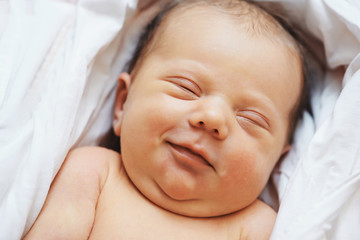 smiling sleeping newborn baby