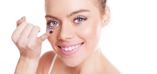 Beautiful woman inserting a contact lens