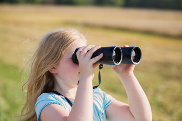girl looking through binoculars outdoor