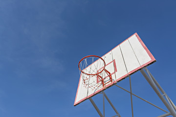 Basketball hoop against the warm summer sky