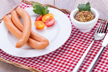 leckere wiener würstchen mit senf auf einem holztisch