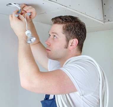 Certified electrician installing socket for light bulb