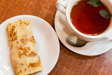 Pancakes with strawberry jam and tea with mint