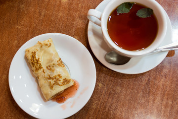 Pancakes with strawberry jam and tea with mint