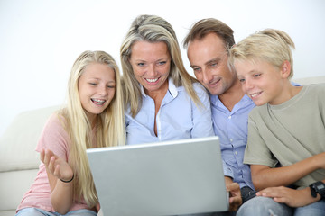 Family connected on internet with laptop