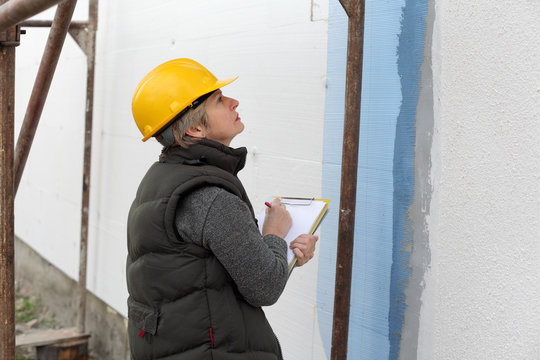 Construction inspector examine insulation of house facade wall