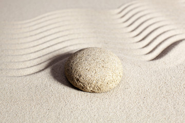 Fototapeta na wymiar waves in sand and round stone for meditation