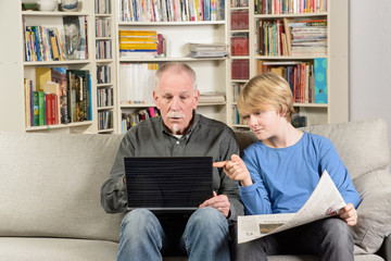 Ein Enkel erklärt dem Senior den Computer