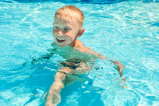Little boy swims in pool
