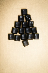 Christmas tree made of black computer keys, golden background