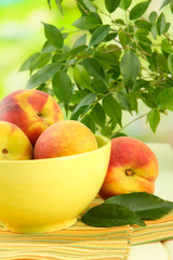 Ripe sweet peaches on table in bowl, outdoors