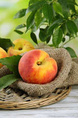 Ripe sweet peaches on wooden table in garden, close up