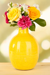 Beautiful bouquet of bright flowers in color vase,