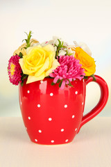 Beautiful bouquet of bright flowers in color mug,