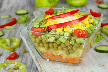 Tasty salad with fresh vegetables on wooden table