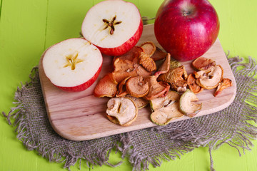 Dried apples, on cutting board,  on color wooden background