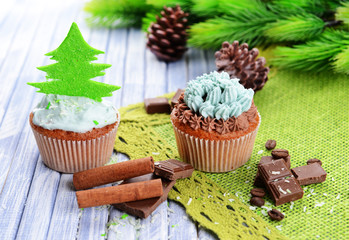 Tasty cupcakes with butter cream, on color wooden background