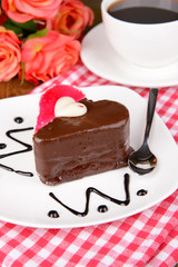 Sweet cake with chocolate on plate on table close-up