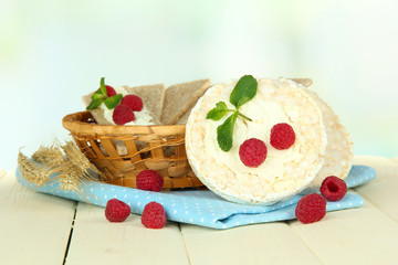 Tasty crispbread with berries in wicker basket, on white table