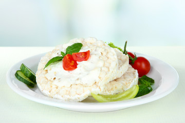 Tasty crispbreads with vegetables on white table