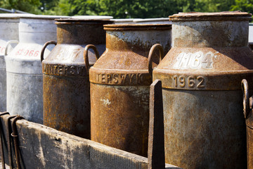 Obraz premium Old milk churns on a cart