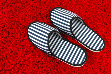 Striped slippers on carpet background