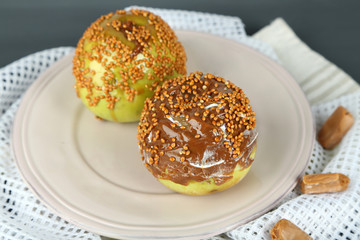 Homemade taffy apples, on napkin, on wooden background