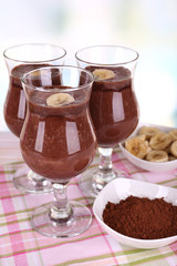 Cocktails with banana and chocolate on table on light