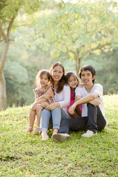 Happy Asian family in park
